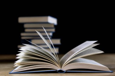 Ahşap bir masa üzerinde okuma kitap yığını. Yalan yok. Siyah bac