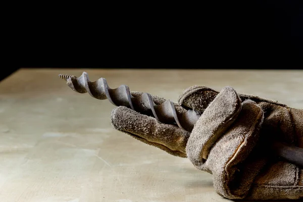 Hand in glove with tool for work in workshop. Hand protected by — Stock Photo, Image