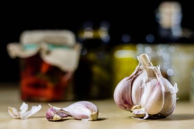 Taze sarımsak kokulu mutfak masasının üstünde. Harç ve kitchenwa