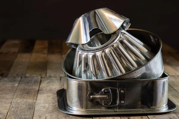 Old baking molds on an old kitchen table. Baking accessories in — Stock Photo, Image