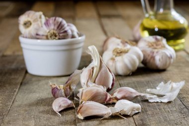Tasty garlic on a wooden kitchen table. Vegetables in the kitche clipart
