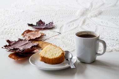 Bir sonbahar günü, bir fincan lezzetli çay ve kek. Yanında kuru akçaağaç 