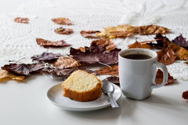 Bir sonbahar günü, bir fincan lezzetli çay ve kek. Yanında kuru akçaağaç 