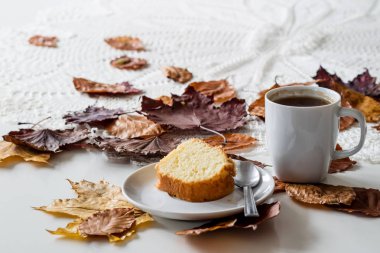 Bir sonbahar günü, bir fincan lezzetli çay ve kek. Yanında kuru akçaağaç 