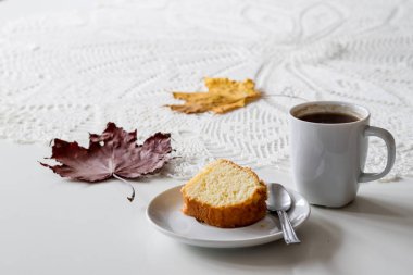 Bir sonbahar günü, bir fincan lezzetli çay ve kek. Yanında kuru akçaağaç 