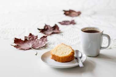 Bir sonbahar günü, bir fincan lezzetli çay ve kek. Yanında kuru akçaağaç 