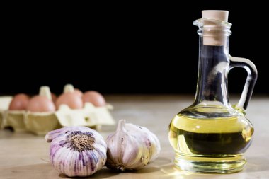 Sarımsak, yumurta ve yağı bir ahşap mutfak masasında. Mutfak pro ile