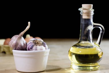 Sarımsak, yumurta ve yağı bir ahşap mutfak masasında. Mutfak pro ile