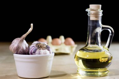 Sarımsak, yumurta ve yağı bir ahşap mutfak masasında. Mutfak pro ile
