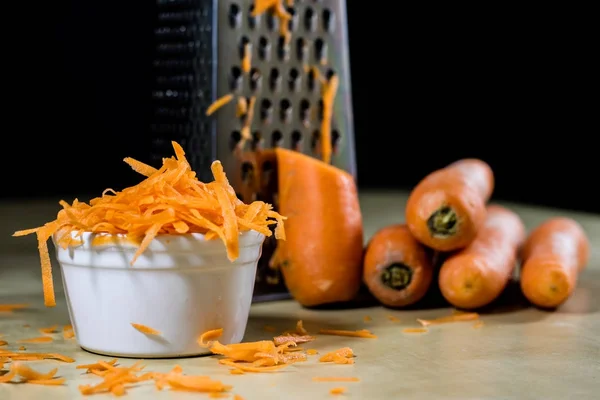 Морковь на кухонном столе. Растительная терка. Кухонный стол . — стоковое фото