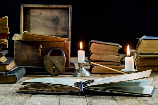 Old books and candles on a wooden table. Old room, reading room.