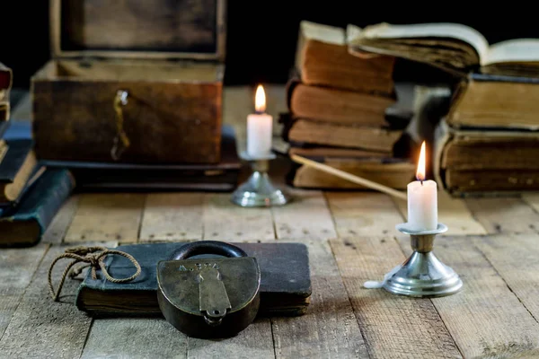 Livros velhos e velas em uma mesa de madeira. Quarto velho, sala de leitura . — Fotografia de Stock