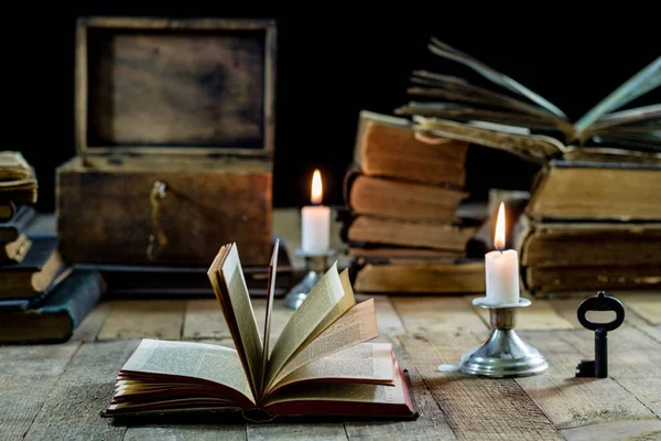 Livros velhos e velas em uma mesa de madeira. Quarto velho, sala de leitura . — Fotografia de Stock