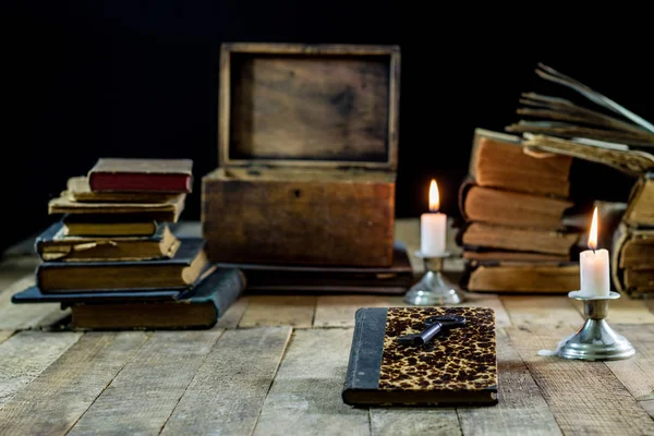 Oude boeken en kaarsen op een houten tafel. Oude kamer, leeskamer. — Stockfoto