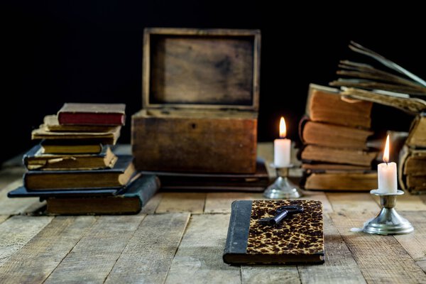 Old books and candles on a wooden table. Old room, reading room.
