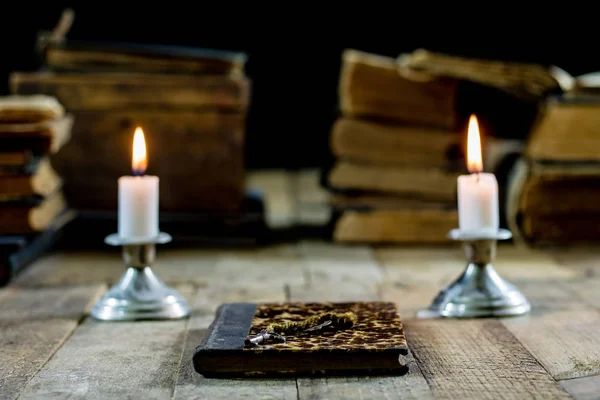 Old books and candles on a wooden table. Old room, reading room.