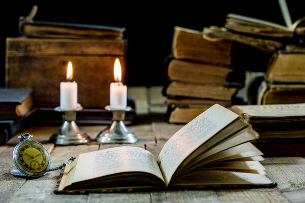Old books and candles on a wooden table. Old room, reading room.