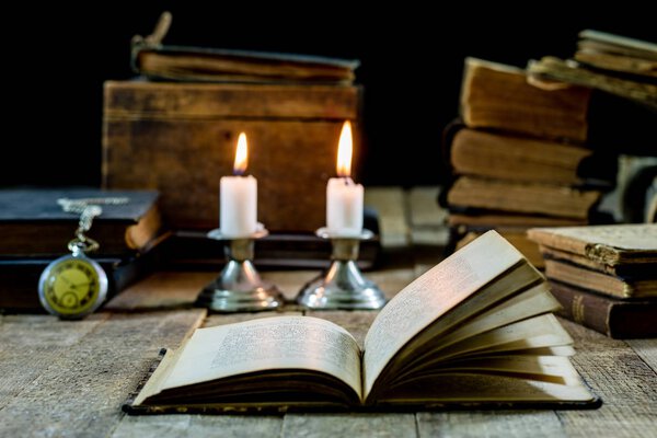 Old books and candles on a wooden table. Old room, reading room.