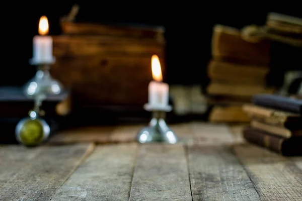 Livros velhos e velas em uma mesa de madeira. Quarto velho, sala de leitura . — Fotografia de Stock