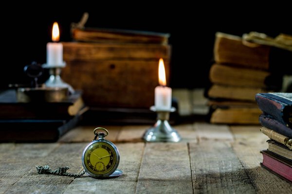 Old books and candles on a wooden table. Old room, reading room.