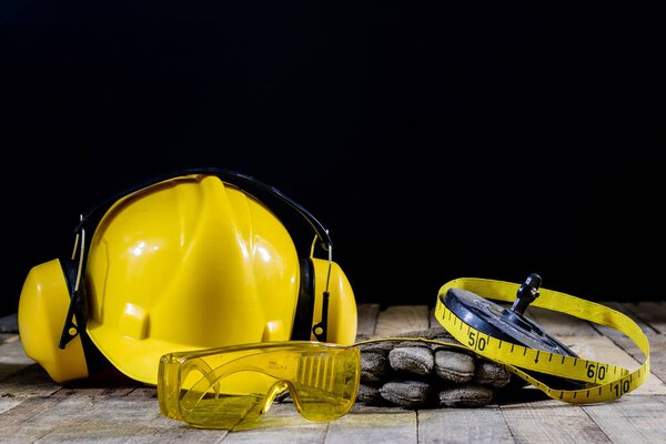 helmet, hearing protection, tools, workshop table. Safety equipm