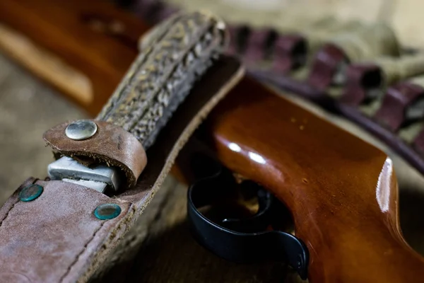 Tiro, pneumático e armas de fogo em uma mesa de madeira. Quadro sobre a — Fotografia de Stock