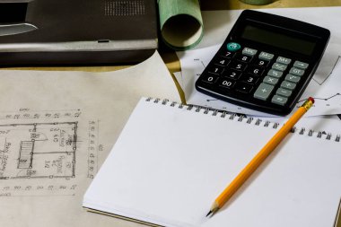 Mimar'ın masa, dizüstü bilgisayar, hesap makinesi masanın üzerinde. Plan, proje