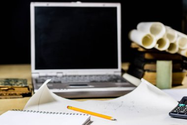 Mimar'ın masa, dizüstü bilgisayar, hesap makinesi masanın üzerinde. Plan, proje
