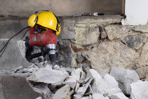 Demolition of walls. Electric hammer helmet and hearing protecti