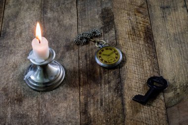 Yanan Mum ve ahşap bir masa üzerinde eski saati. Akan zaman ve