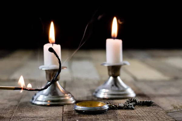 Velas que queimam em castiçais em uma mesa de madeira. Vela de prata — Fotografia de Stock