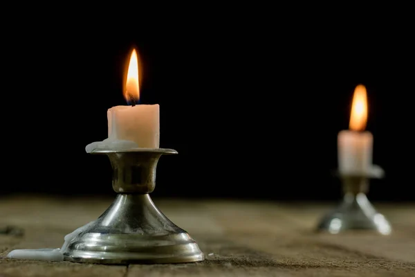Ljus brinnande i ljusstakar på ett träbord. Silver ljusstake — Stockfoto
