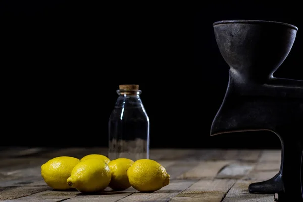 Vieja máquina de jugo de hierro fundido en una mesa de cocina de madera. Limón jui — Foto de Stock