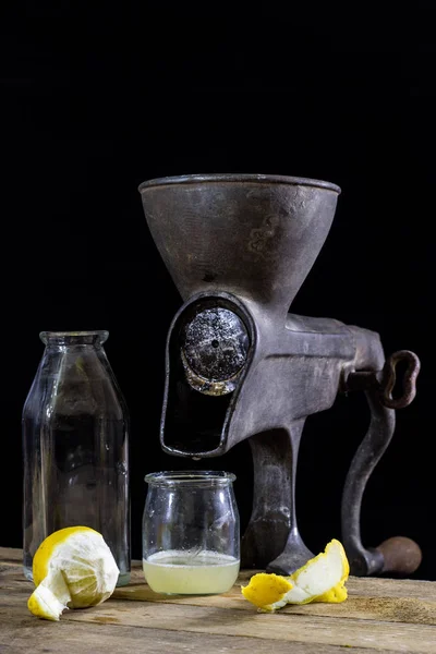 Vecchia macchina del succo di ghisa su un tavolo da cucina in legno. Succo di limone — Foto Stock