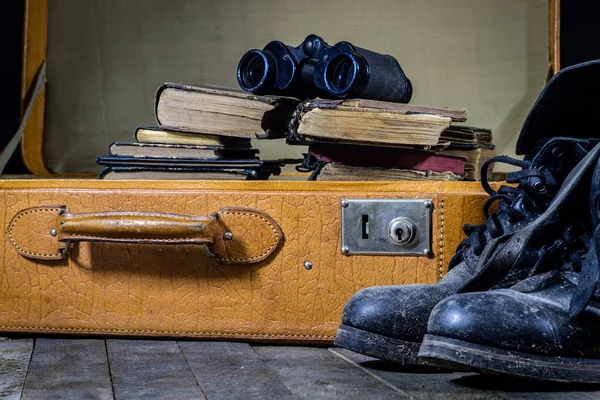 Old stylish suitcase. Old books in a suitcase. Suitcase on a woo