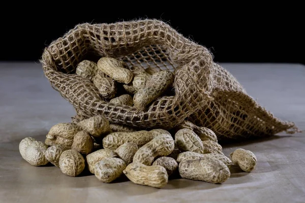 Fresh nuts in a jute bag on a wooden kitchen table. Italian haze — Stock Photo, Image