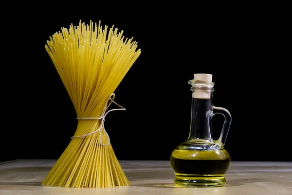 Pasta e olio d'oliva su un vecchio tavolo da cucina. Ricette nel vecchio libro — Foto Stock