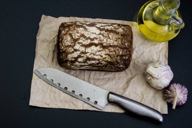 Siyah gri kağıt üzerinde ekmek. Baharat ve yağı brea dilim yanında