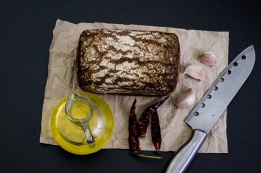 Siyah gri kağıt üzerinde ekmek. Baharat ve yağı brea dilim yanında