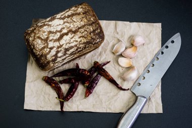 Siyah gri kağıt üzerinde ekmek. Baharat ve yağı brea dilim yanında