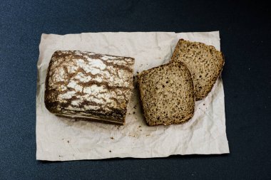 Siyah gri kağıt üzerinde ekmek. Baharat ve yağı brea dilim yanında