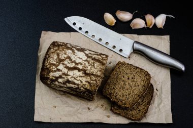 Siyah gri kağıt üzerinde ekmek. Baharat ve yağı brea dilim yanında