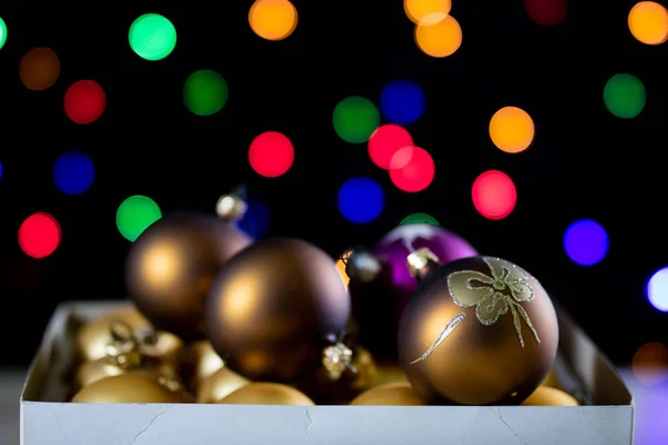 Le bagattelle di Natale in una scatola su uno sfondo di Natale lig — Foto Stock