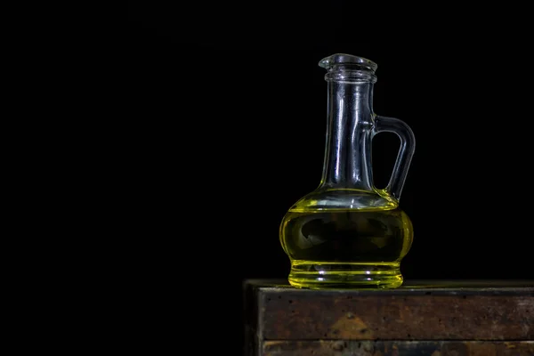 Uma garrafa de óleo de vidro em uma caixa de madeira velha. Óleo em um velho — Fotografia de Stock