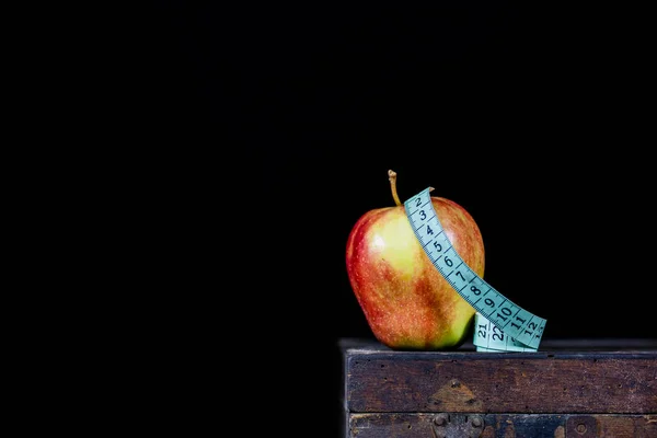 Schmackhafter Apfel auf einem alten dunklen Holztisch. Maßband neben dem Geschmack — Stockfoto