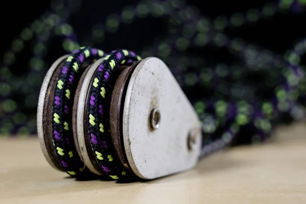 Takelage, Segel-Zubehör. Seilblock und Schekel auf einem Holztisch. schwarzer Hintergrund — Stockbild Takelage, Segel-Zubehör. Seilblock und Schekel auf einem Holz — Stockfoto