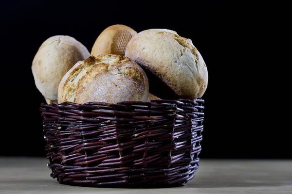 Pão fresco saboroso em uma cesta de vime. Rolos em uma cesta em um woo — Fotografia de Stock
