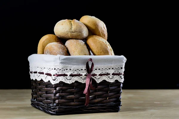 Pão fresco saboroso em uma cesta de vime. Rolos em uma cesta em um woo — Fotografia de Stock