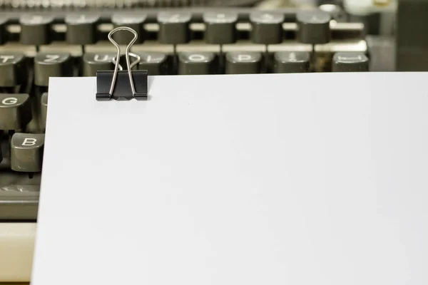 Una tarjeta blanca con un clip en una máquina de escribir. Hojas de papel ingenio —  Fotos de Stock