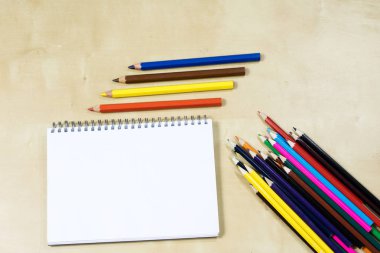 Ahşap bir masa üzerinde çizim kalem ve bir eskiz defter. Kaşar